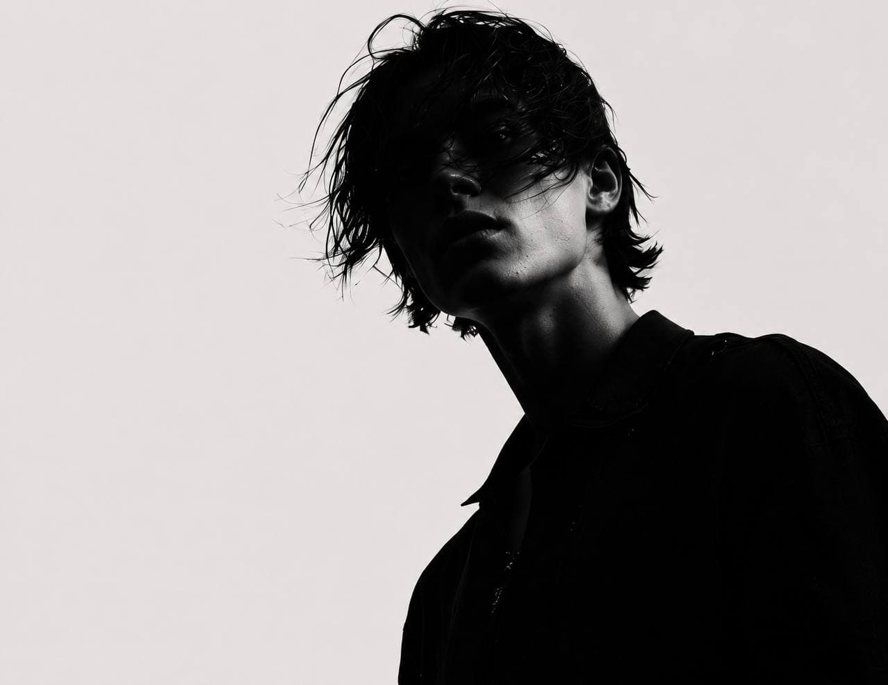 Tall dark editorial figure on a pale background